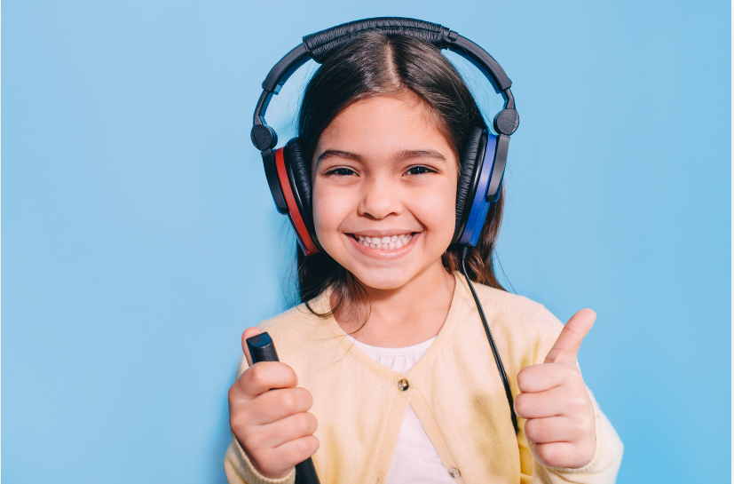 A child wearing headphones and has their thumb up.