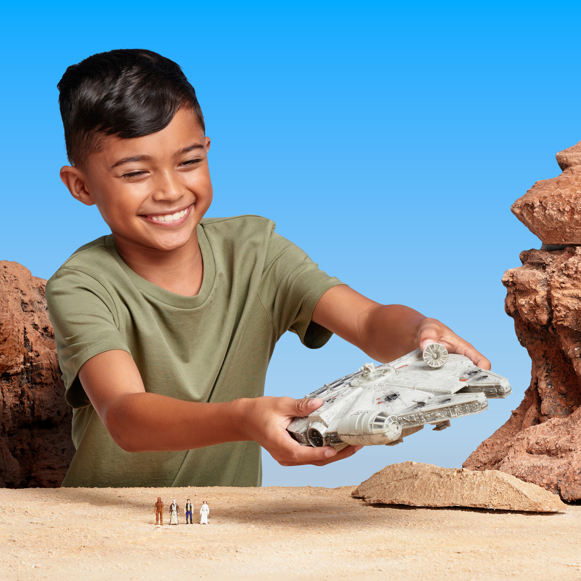 Young boy plays with a stars wars toy called the Star Wars Micro Galaxy Squadron Millenium Falcon Playset.