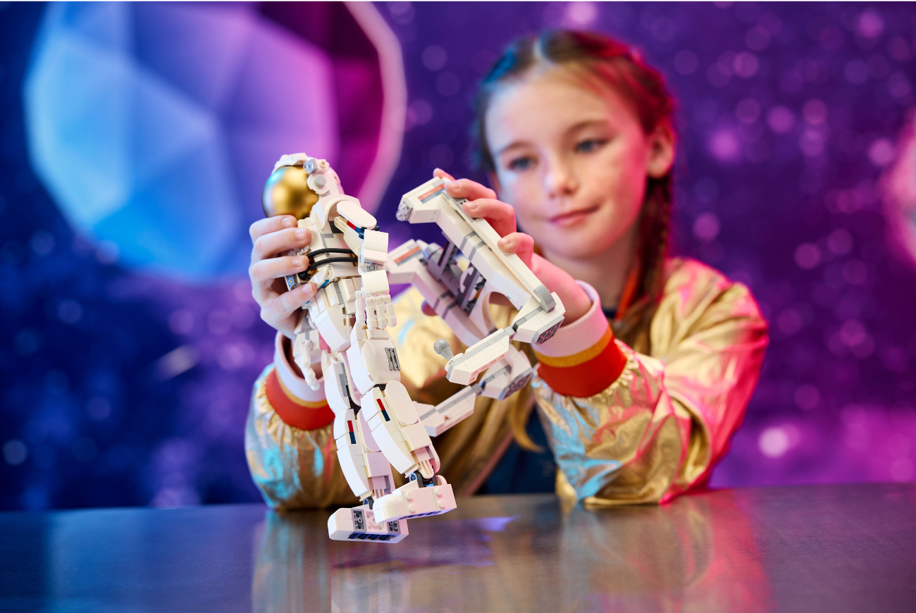 Young girl plays with a lego space toy.