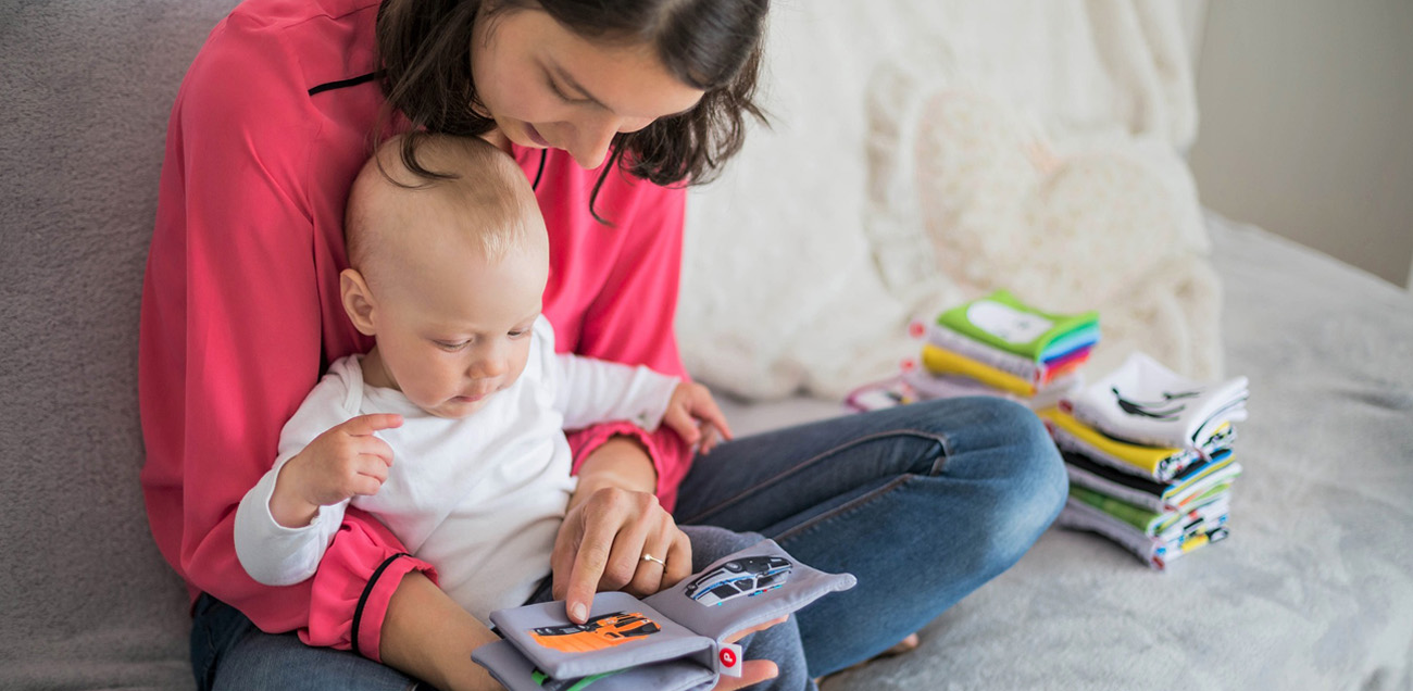 Mother and baby looking at a soft book