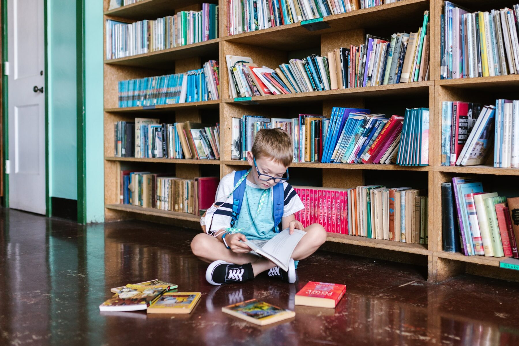 Boy sitting in library reading.