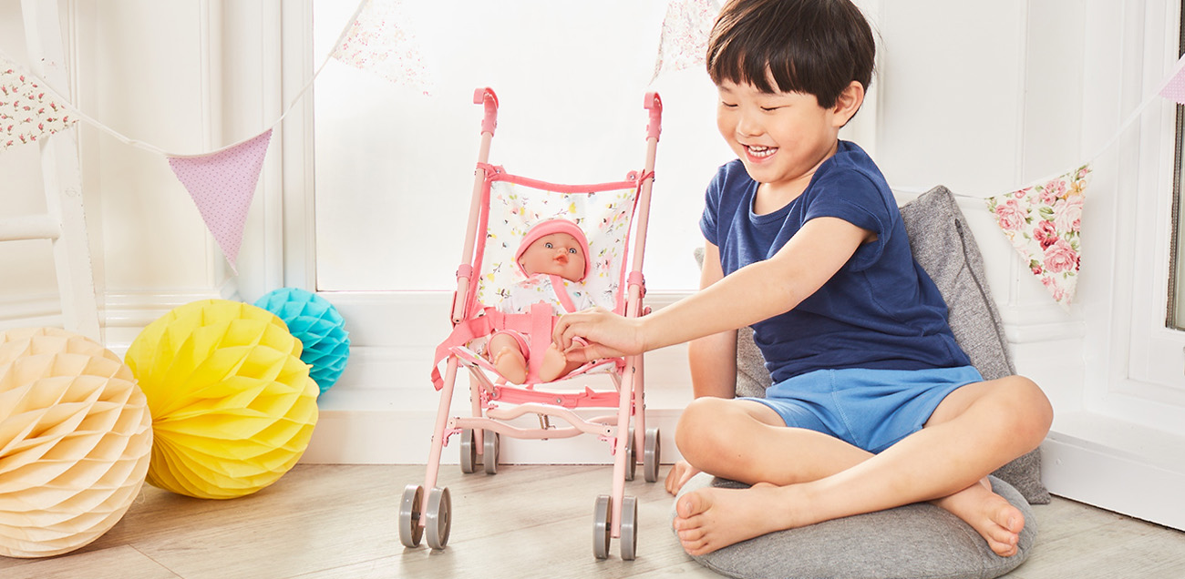 child with baby doll in a pushchair