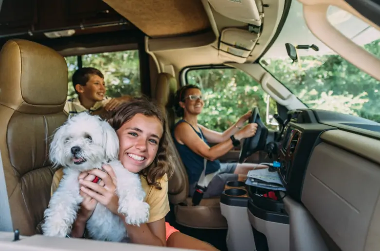 Family and two children in the car ready for a road trip.