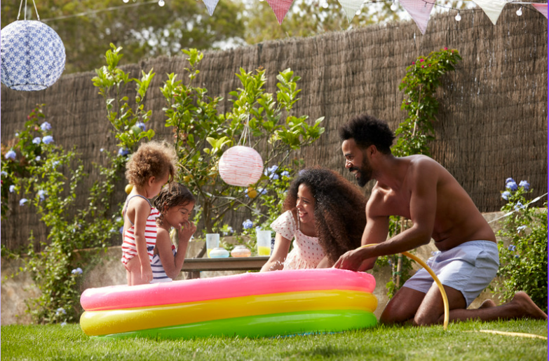 Family sat in a paddling pool.