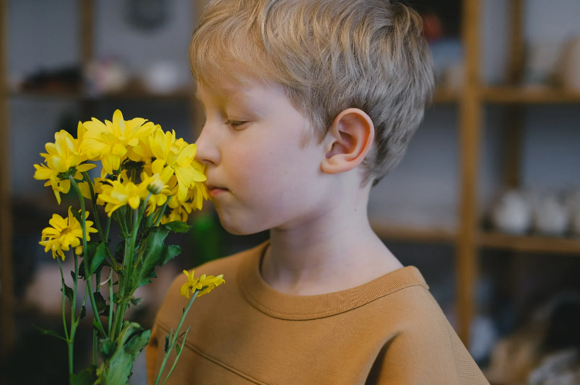 A child smelling flowers.